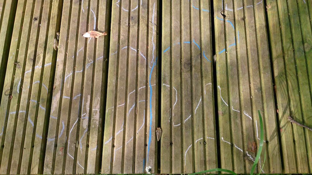 blue and white lines drawn around shadows on the decking