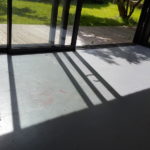 grass, decking, window, studio and white lines drawn around the shadows