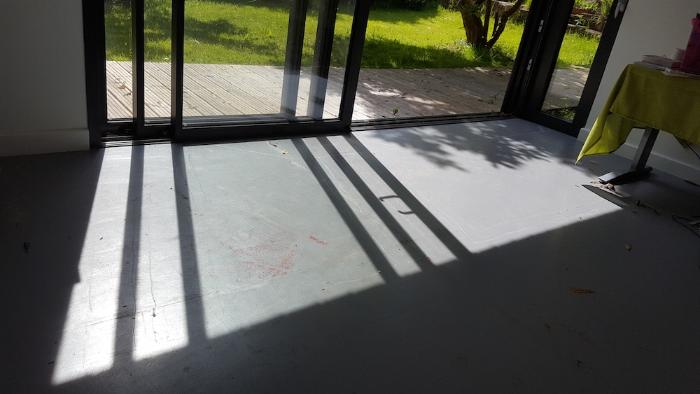 grass, decking, window, studio and white lines drawn around the shadows